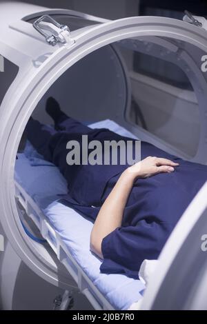 Paziente femminile in camera iperbarica di ossigeno HBOT Foto Stock