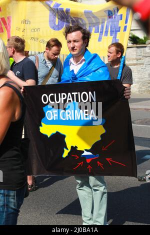 Varsavia, Polonia - 27th luglio 2014: Un uomo ha un poster di occupazione Crimea. Foto di alta qualità Foto Stock