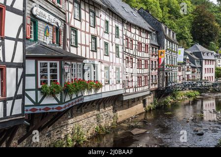 Città vecchia di Monschau, Renania settentrionale-Vestfalia - Germania - 08 27 2019 turisti seduti su una terrazza soleggiata circondata da decorazioni tradizionali a graticcio Foto Stock