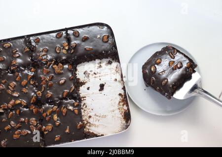 Fetta di torta di Texas servita su un piatto. Torta di burro e cioccolato tagliata a pezzi rettangolari all'interno del cestino da forno e tagliata a pezzi da esso. Shot o Foto Stock