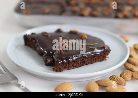 Fetta di torta di Texas servita su un piatto. Torta di burro e cioccolato tagliata a pezzi rettangolari all'interno del cestino da forno e tagliata a pezzi da esso. Shot o Foto Stock