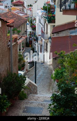 Strade strette e scalinate tra carino case italiane nella città vecchia di Scilla Foto Stock