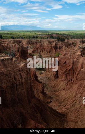 Ripida scogliera e della valle di arancia rossa pietra arenaria rock formazione nel caldo deserto Tatacoa sotto il cielo blu, Huila Foto Stock