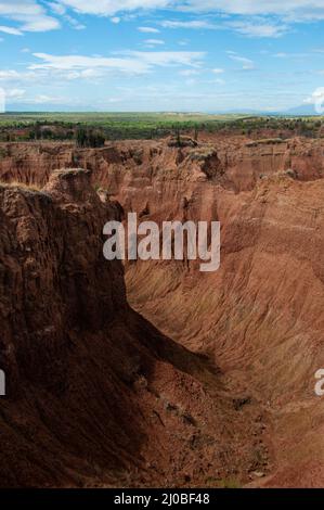 Ripida scogliera e della valle di arancia rossa pietra arenaria rock formazione nel caldo deserto Tatacoa sotto il cielo blu, Huila Foto Stock