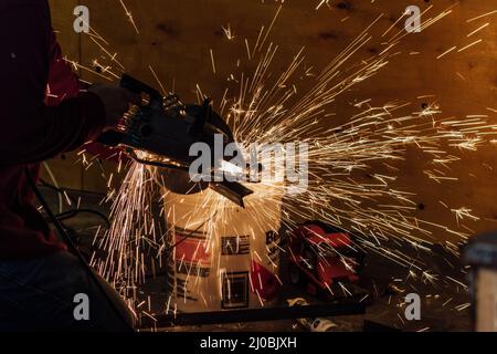 Scintille che volano da un metallo da saldare Foto Stock