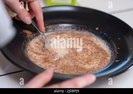 Toast alla francese. Mescolare il latte, l'uovo e la cannella in un recipiente. Foto Stock