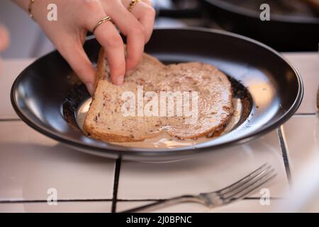 Toast alla francese. Immergete il pane nel latte, nelle uova e nella cannella in un recipiente. Foto Stock