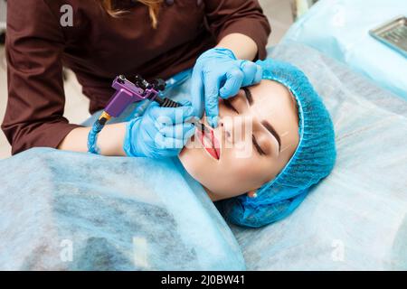 Cosmetologo rendendo trucco permanente sul volto di donna Foto Stock