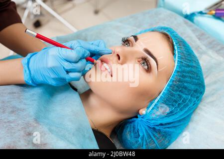 Cosmetologo rendendo trucco permanente sul volto di donna Foto Stock