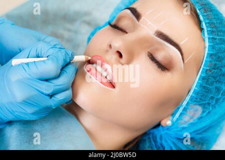 Cosmetologo rendendo trucco permanente sul volto di donna Foto Stock