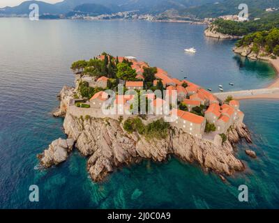 Aerofotografia. Vista dal drone volante. Vista panoramica dell'isola di Sveti Stefan a Budva in una splendida giornata estiva, Montenegro. Vista dall'alto. Bellissima Foto Stock