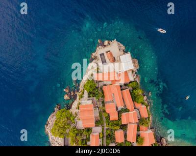 Aerofotografia. Vista dal drone volante. Vista panoramica dell'isola di Sveti Stefan a Budva in una splendida giornata estiva, Montenegro. Vista dall'alto. Bellissima Foto Stock