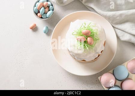 Torta di Pasqua e uova rosa colorate su sfondo bianco. Spazio per il testo. Foto Stock