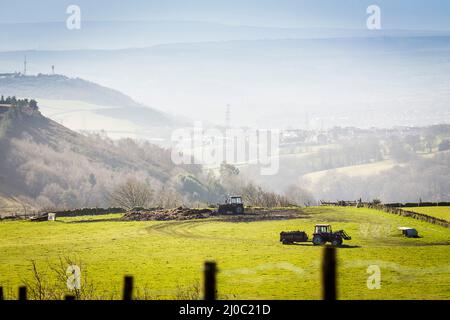 Shibden Valley, West Yorkshire, Regno Unito. 18th marzo 2022. Il britannico Weather.A coltivatore si diffonde muck mentre prepara i suoi campi per l'anno prossimo nella valle di Shibden vicino Halifax, Calderdale, Regno Unito. La valle è l'impostazione della serie televisiva Gentleman Jack che serializza la vita di Anne Lister. Credit: Windmill Images/Alamy Live News Foto Stock