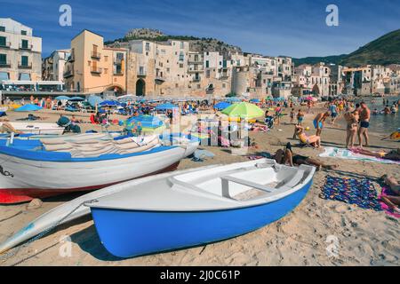 Persone non identificate sulla spiaggia sabbiosa di Cefalu, Sicilia, Italia Foto Stock