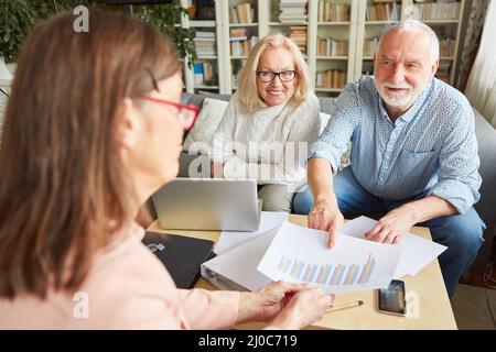 Gli anziani discutono i risparmi di pensione e la tabella di investimento con il loro consulente fiscale Foto Stock