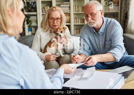 Coppia senior e consulente fiscale con le ricevute che preparano la dichiarazione dei redditi Foto Stock