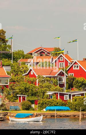 Tipiche case in legno rosso svedese con barche nella città di Karlskrona Foto Stock