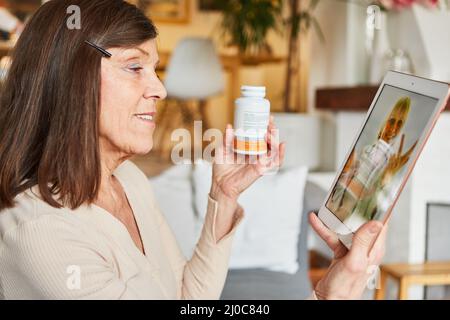 Donna anziana sul computer tablet durante una consultazione online con un medico come telemedicina Foto Stock