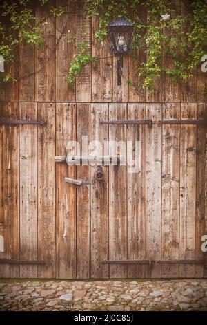 Weathered vecchio fienile in legno porta con cerniere in acciaio Foto Stock