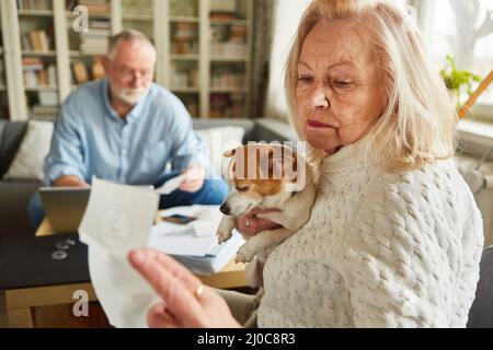 Vecchia donna preoccupata guardando una fattura o una ricevuta nella contabilità nel paese Foto Stock