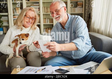 Coppia anziana felice che ordina le ricevute in contabilità per la dichiarazione di imposta Foto Stock