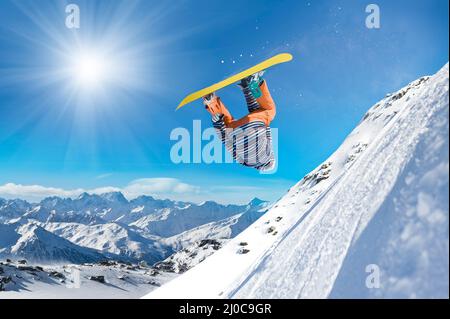 Uomo di snowboard estremo. Lo snowboarder salta in alto nell'aria Foto Stock