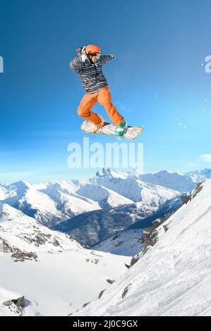 Uomo di snowboard estremo. Lo snowboarder salta in alto nell'aria Foto Stock