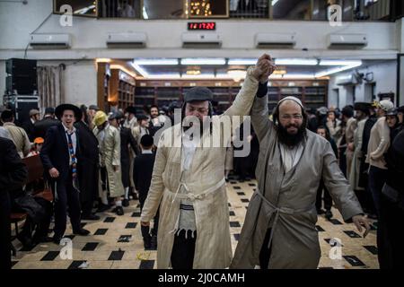 Gerusalemme, Israele. 18th Mar 2022. Gli uomini ebrei ultraortodossi prendono parte alle celebrazioni della festa ebraica di Purim nel quartiere strettamente religioso di Mea She'arim a Gerusalemme. Purim, chiamato anche il Festival dei lotti, è una festa ebraica di carnevale celebrata con parate e stune per commemorare il salvataggio del popolo ebraico da un complotto per massacro di tutti gli ebrei nell'antico impero persiano, come raccontato nel Libro di Esther. Credit: Ilia Yefimovich/dpa/Alamy Live News Foto Stock