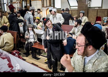 Gerusalemme, Israele. 18th Mar 2022. Gli ebrei ultraortodossi prendono parte alle celebrazioni della festa ebraica di Purim nel quartiere strettamente religioso di Mea She'arim a Gerusalemme. Purim, chiamato anche il Festival dei lotti, è una festa ebraica di carnevale celebrata con parate e stune per commemorare il salvataggio del popolo ebraico da un complotto per massacro di tutti gli ebrei nell'antico impero persiano, come raccontato nel Libro di Esther. Credit: Ilia Yefimovich/dpa/Alamy Live News Foto Stock