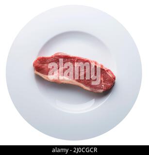Pezzo unico di carne cruda su un piatto bianco isolato su bianco. Vista dall'alto dell'antenna Foto Stock