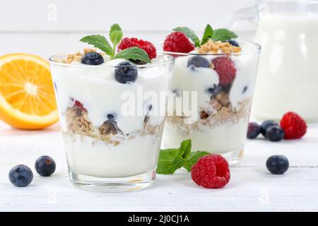 Bacche yogurt bacche di vetro frutta cereali piatto colazione in legno Foto Stock