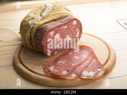 Spinata Salami in stoffa servito su un piatto di legno Foto Stock