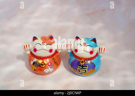 Gatti giapponesi (maneki neko) in porcellana. Sono simboli tradizionali di Buona fortuna. Foto Stock
