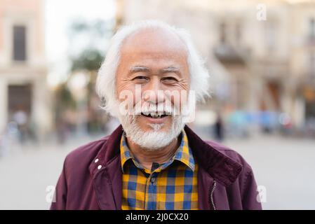 Ritratto di uomo anziano asiatico felice sorridente davanti alla macchina fotografica Foto Stock