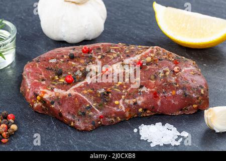 Bistecca di carne di manzo crudo su piatto di ardesia Foto Stock
