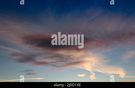 Nuvole di sgombro contro un cielo blu la sera Foto Stock