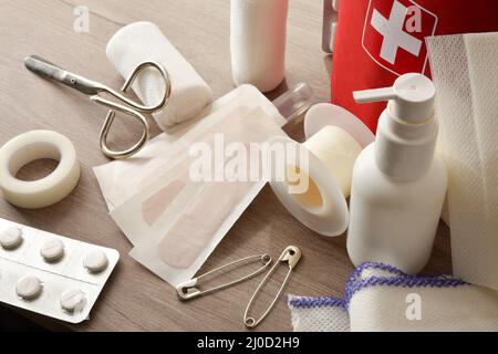 Kit di emergenza casa su tavolo di legno e sfondo stanza calda. Composizione orizzontale. Vista rialzata. Foto Stock