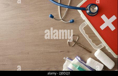 Sfondo con apparecchiature mediche portatili per una rapida assistenza in ospedale su tavolo di legno. Composizione orizzontale. Vista dall'alto. Foto Stock