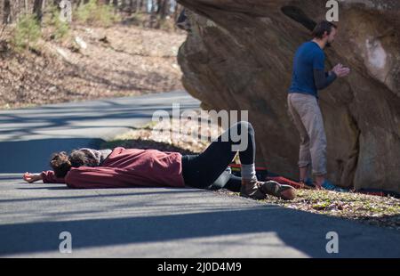 Donna outdoor sdraiata su strada all'aperto film rock climber iniziare una salita Foto Stock