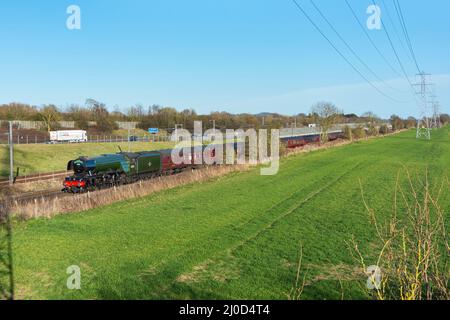 La famosa locomotiva a vapore Flying Scotsman di proprietà del National Railway Museum passa attraverso la campagna del Kent lungo il lato M20, Sellindge Kent. Foto Stock