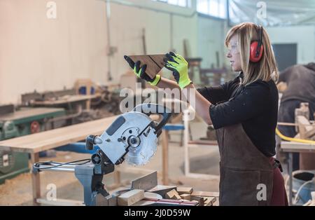 Carpentiere femmina con sega circolare per legno Foto Stock