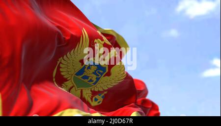 Dettaglio della bandiera nazionale del Montenegro che sventola nel vento in una giornata limpida. Il Montenegro è un paese dell'Europa sudorientale. Messa a fuoco selettiva. Foto Stock