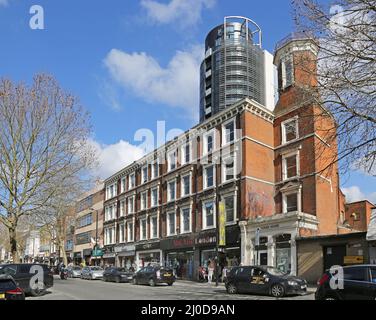 Finsbury Park, Londra, Regno Unito. Negozi su Fonthill Road con torri del nuovo sviluppo residenziale City North sullo sfondo. Foto Stock