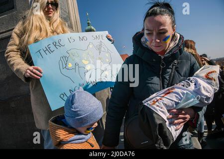 Varsavia, Polonia. 18th Mar 2022. Una madre Ucraina e il suo bambino prendono parte alla protesta. A Varsavia si è tenuta la "arca delle madri ucraine", che è stata anche una protesta contro la guerra e l'uccisione di bambini ucraini. Gli slogan della marcia sono stati "mondo, aiutare i nostri figli", "Stop the war", "salvare i bambini dell'Ucraina" e "chiudere il cielo". Alla protesta hanno partecipato soprattutto madri ucraine e loro figli, che hanno trovato rifugio in Polonia dalla guerra. Credit: SOPA Images Limited/Alamy Live News Foto Stock