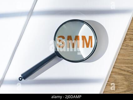 Acronimo SMM. Social media marketing attraverso lente di ingrandimento.foto Foto Stock