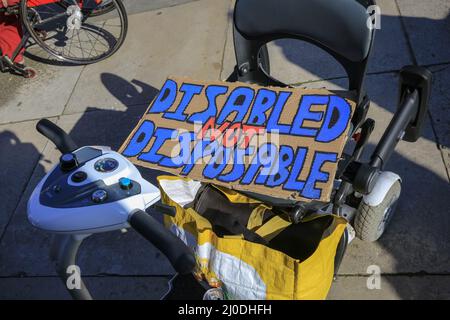 Londra, Regno Unito. 18th Mar 2022. Un cartello si trova in modo poignoso in uno scooter per la mobilità vuoto, i manifestanti in Piazza del Parlamento. Un raduno organizzato dalle reti d'azione diretta dei disabili vede le persone protestare contro ciò che percepiscono come un fallimento da parte del governo di proteggere adeguatamente i disabili durante la pandemia covida in corso. Credit: Imagplotter/Alamy Live News Foto Stock