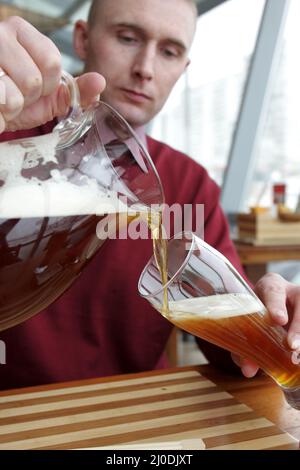 L'uomo che versa una birra in un ristorante Foto Stock