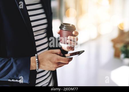 Egli tiene il segreto del successo. Scatto corto di un uomo d'affari che usa un telefono cellulare in un ufficio moderno. Foto Stock