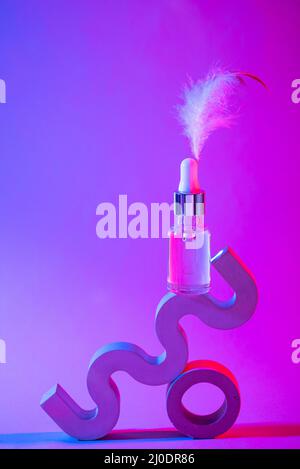 Flacone di siero cosmetico in luce al neon Foto Stock